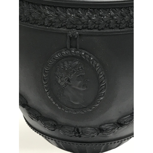 323 - A Neale or Hanley black basalt urn with classical design, restoration to column. 22cm.