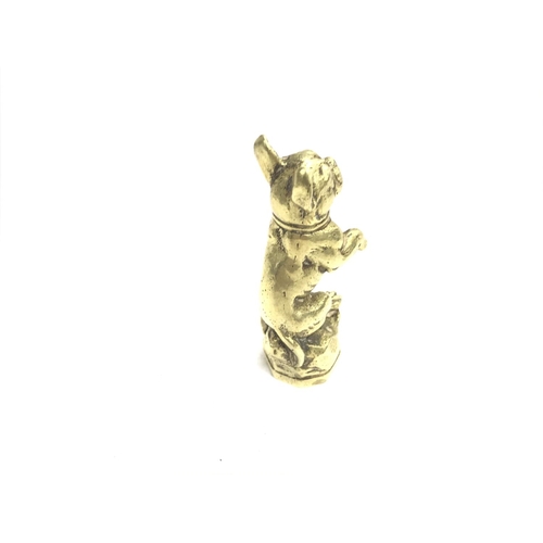 381 - A brass pipe tamper in the style of a dog. Approximately 2 1/2inches tall.