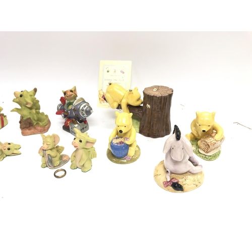 501 - A collection of whimsical dragon figurines and royal Doulton Winnie the Pooh figures.