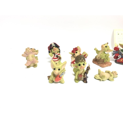 501 - A collection of whimsical dragon figurines and royal Doulton Winnie the Pooh figures.