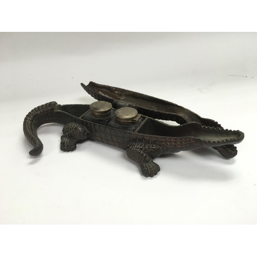 802 - A cast iron inkwell in the form of a crocodile inset with two bottles, approx length 25cm.