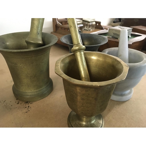 828 - A collection of four mortar and pestles .