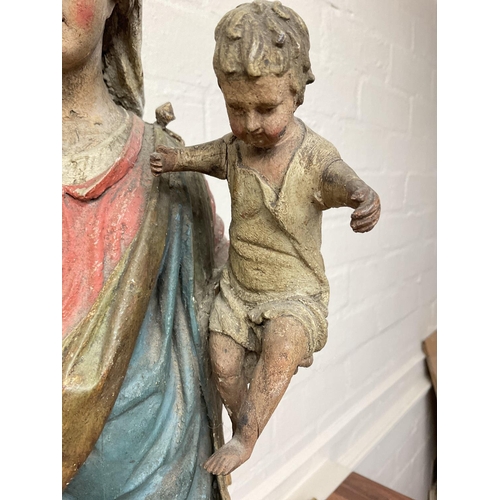 868 - An early Victorian carved wooden statuette of Madonna and child with polychrome painted body. 60cm