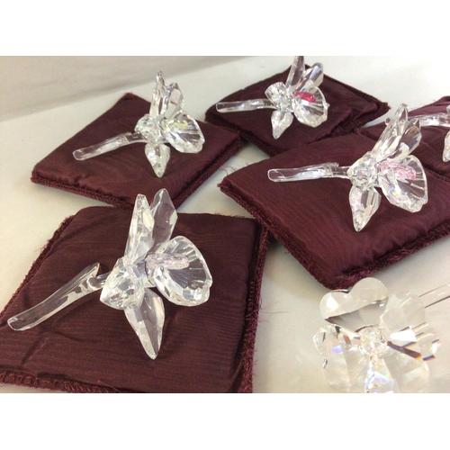 1007 - Five Swarovski orchid flowers with varying coloured centres. Together with a Swarovski Four leaf clo... 