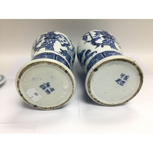 1225 - A pair of blue and white vases with covers having fo dog finials, approx total height 29cm.