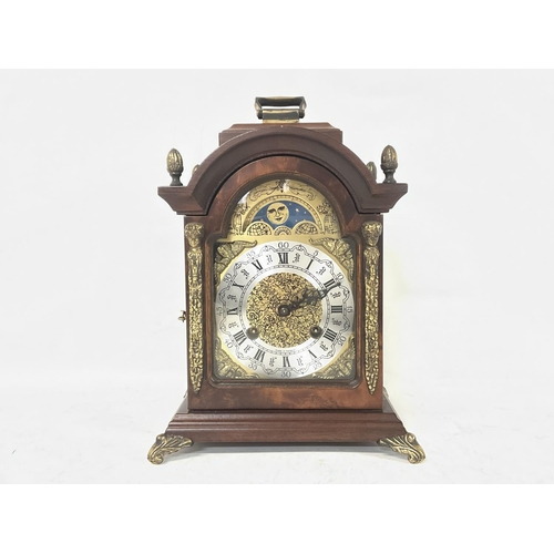 1339 - Franz Hermle Burr Walnut mantel clock with an arched dial with sun and moon phase with Roman and Ara... 