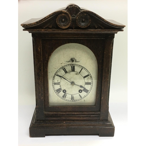 1352 - An oak mantle clock with a silvered dial, approx height 35cm. Comes with key and pendulum.