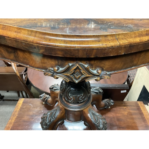 1356 - A Victorian walnut card table the twin flap top above a carved column on cabriole legs .