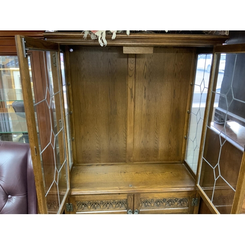 1424 - An oak glazed 2 door cabinet with lead glazed front. 161 x 107cm