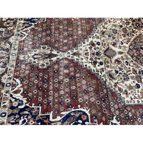 1425 - A large Persian hand knotted wool rug, 318 x 203cm, some fading.