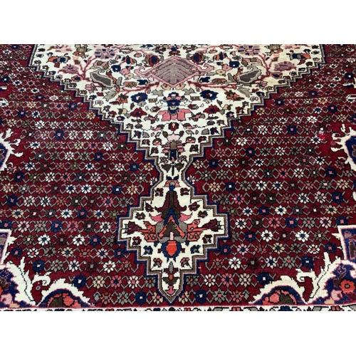 1425 - A large Persian hand knotted wool rug, 318 x 203cm, some fading.