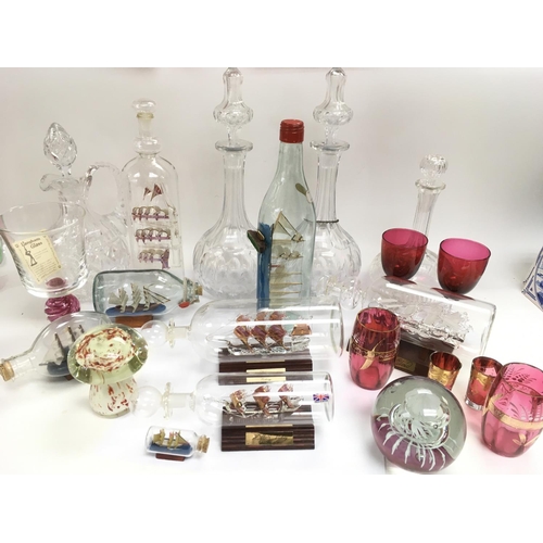 937 - A collection of ship's in bottles, cranberry glass and late Victorian decanters.