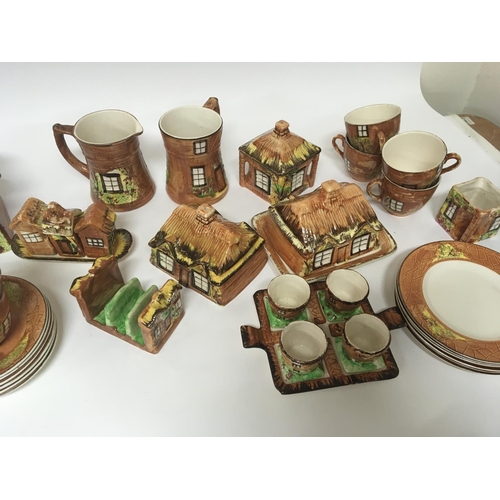 957 - A collection of cottage ware ceramics including biscuit barrels tea pots butter dishes cups saucers ... 