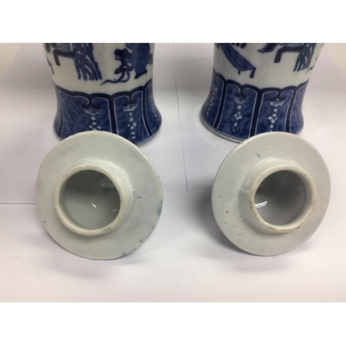 1001 - A pair of blue and white vases with covers having fo dog finials, approx total height 29cm.