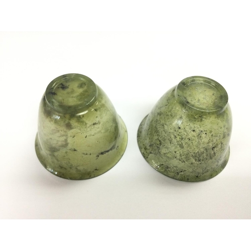 1008 - A par of jade cups on hardwood stands, total approx height 6.5cm. Shipping category D.