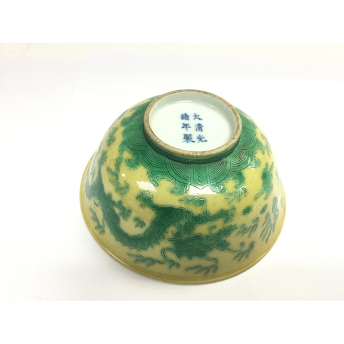 1022 - An Oriental bowl decorated with green dragons on a yellow ground, approx diameter 15cm. Shipping cat... 