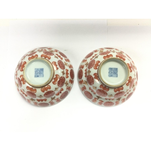 1024 - A pair of Oriental bowls decorated with bats and symbols on a white ground, approx diameter 12cm. Sh... 