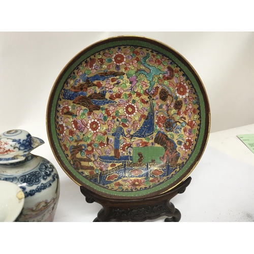 1043 - A late 19th century Chinese export porcelain plate with a hardwood stand the dish decorated with fig... 