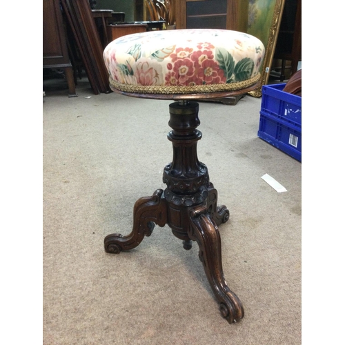 1403 - Revolving and adjustable Victorian walnut music stool with floral seat and a carved tripod base, app... 