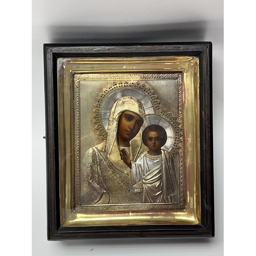 851 - A late 19thC cased Russian icon depicting the Madonna and Child with a Russian hallmarked silver cov... 