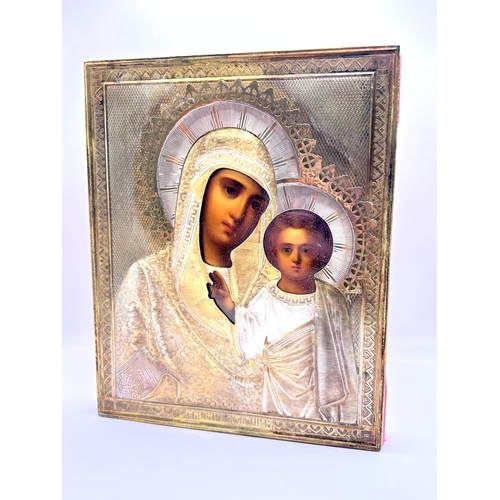 851 - A late 19thC cased Russian icon depicting the Madonna and Child with a Russian hallmarked silver cov... 