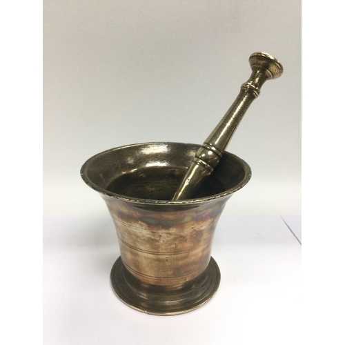 863 - An antique bronzed modtar and pestle and an early 20th Century pharmacy book (2).