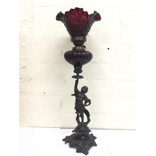 911 - Bronze cherub oil lamp lamp signed Sacha Pan with a ruby red glass reservoir and a ruby glass shade.... 