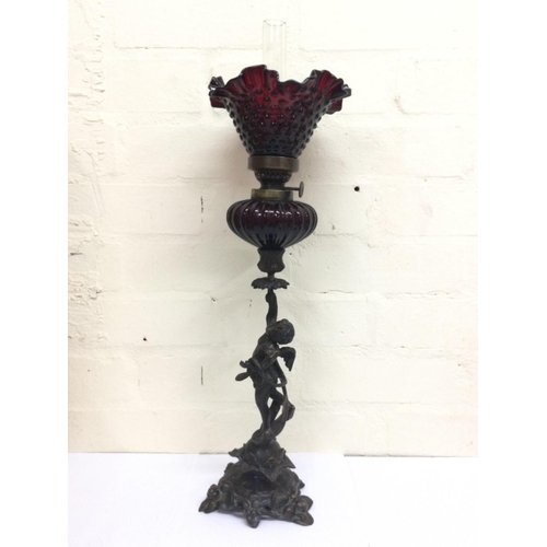 911 - Bronze cherub oil lamp lamp signed Sacha Pan with a ruby red glass reservoir and a ruby glass shade.... 