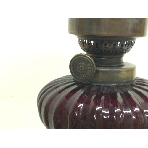 911 - Bronze cherub oil lamp lamp signed Sacha Pan with a ruby red glass reservoir and a ruby glass shade.... 