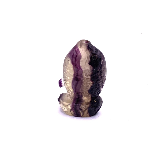 100 - A carved amethyst crystal snuff bottle in the form of a leaping Koi, 6.5cm.