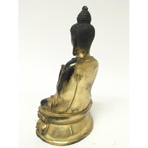 182 - A gilt metal figure of a seated Buddha cast and with an infield base the lower section with a repeat... 