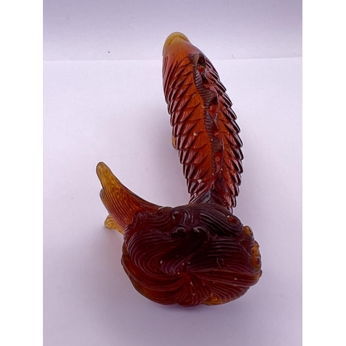 22 - A carved amber glass snuff bottle in the form of a leaping koi, 8.3cm