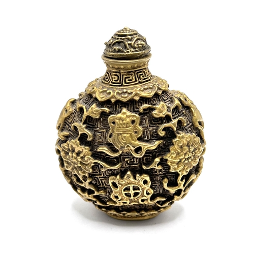 30 - A cast gilt bronze snuff bottle with decoration in the form of Buddhist symbols. Height 7cm.