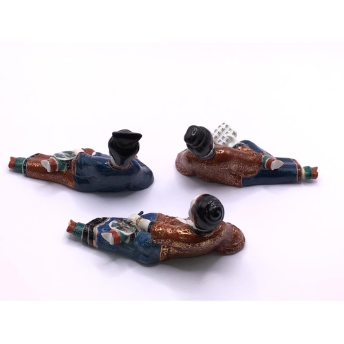 5 - Three bottle enamelled porcelain suite in the form of reclining ladies, each approximately 10cm.