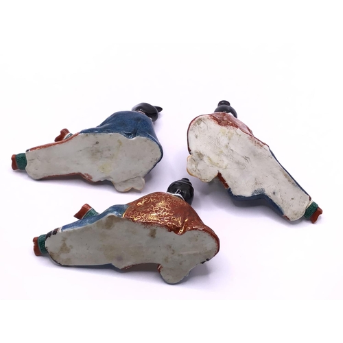 5 - Three bottle enamelled porcelain suite in the form of reclining ladies, each approximately 10cm.