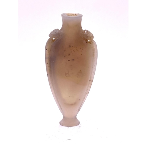 52 - A finely carved elongated carved pale opalescent agate snuff bottle, with lion head motif to the sho... 