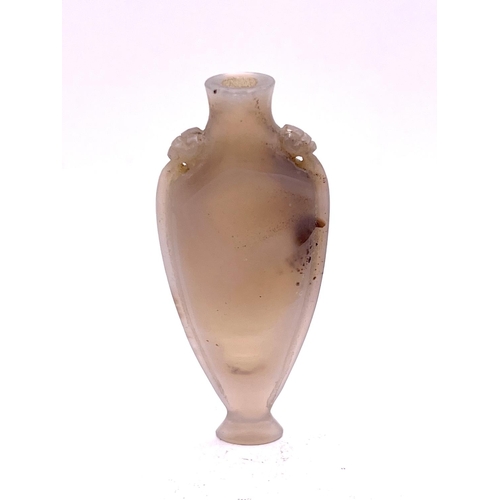 52 - A finely carved elongated carved pale opalescent agate snuff bottle, with lion head motif to the sho... 