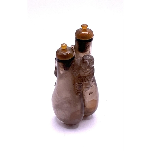 53 - A small double carved rock crystal snuff bottle with matching agate stoppers, 7.3cm.