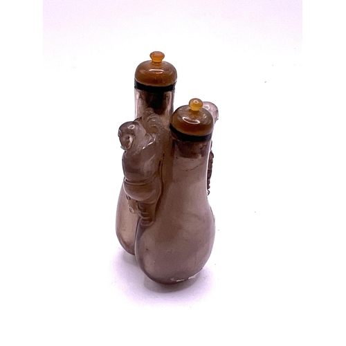 53 - A small double carved rock crystal snuff bottle with matching agate stoppers, 7.3cm.