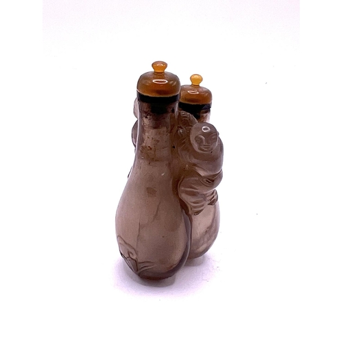 53 - A small double carved rock crystal snuff bottle with matching agate stoppers, 7.3cm.