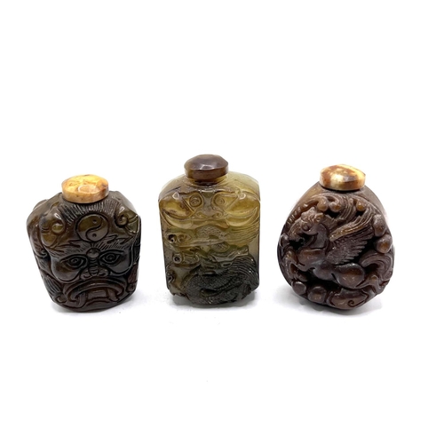 66 - 3 carved hardstone snuff bottles with naive carved decoration to each bottle. H.6cm.