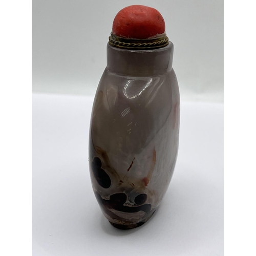 73 - A polished agate snuff bottle with a gilt metal and coral stopper. 8cm.