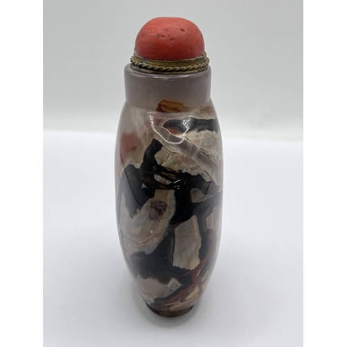 73 - A polished agate snuff bottle with a gilt metal and coral stopper. 8cm.