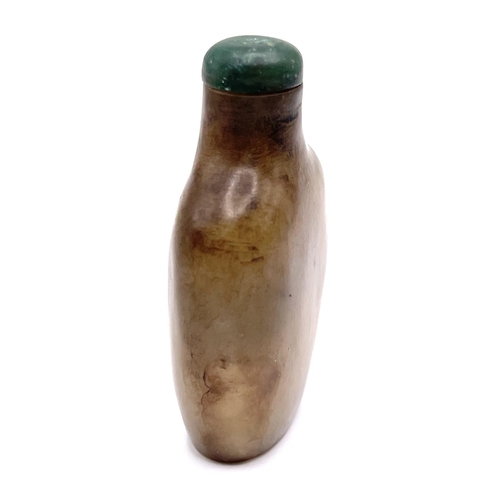 74 - A carved jade snuff bottle with green jade stopper, 6.5cm.