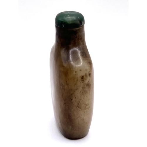 74 - A carved jade snuff bottle with green jade stopper, 6.5cm.