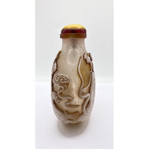 88 - A finely carved 2 layer cameo table snuff bottle depicting a happy Buddah and his followers. 12cm.