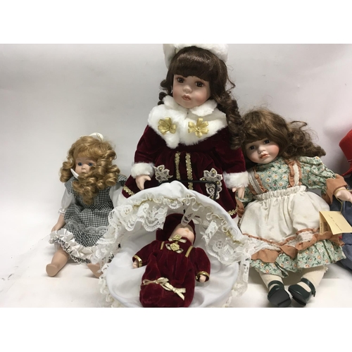 567 - A collection of four porcelain dolls one pushing pram with baby. NO RESEREVE