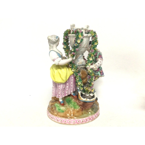 1115 - Porcelain Dresden figure scene, with floral decoration. 20cm tall approximately. Postage cat D