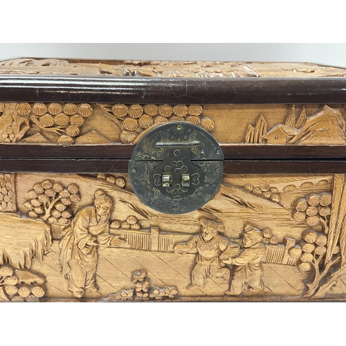 1501 - A small 1920s carved camphor wood lined carved jewellery casket. 30cm x 16cm x 20cm