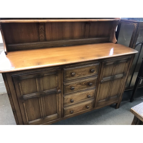 1631 - A oak dresser the raised back above four drawers flanked by cupboards .